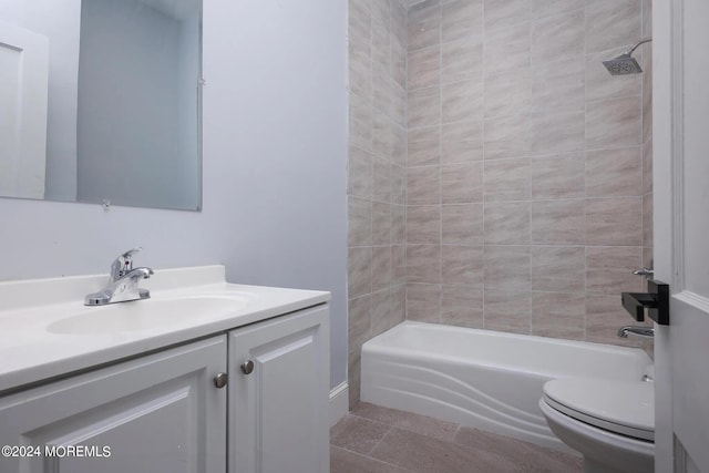 full bathroom with tiled shower / bath, tile patterned floors, vanity, and toilet