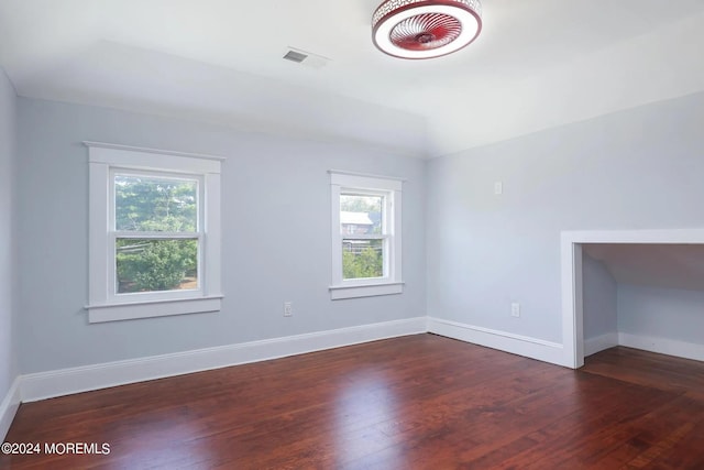 empty room with a healthy amount of sunlight and dark hardwood / wood-style floors