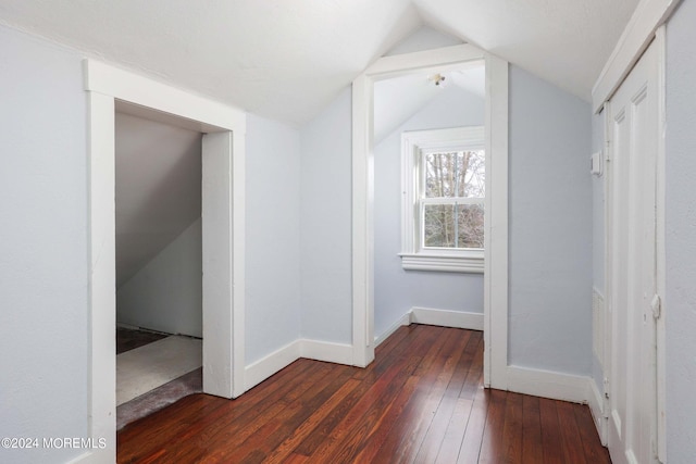 hall featuring dark hardwood / wood-style floors and vaulted ceiling