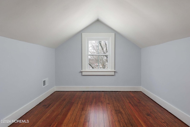 additional living space featuring vaulted ceiling and dark hardwood / wood-style flooring