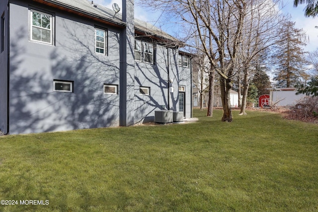 exterior space with central air condition unit and a storage shed