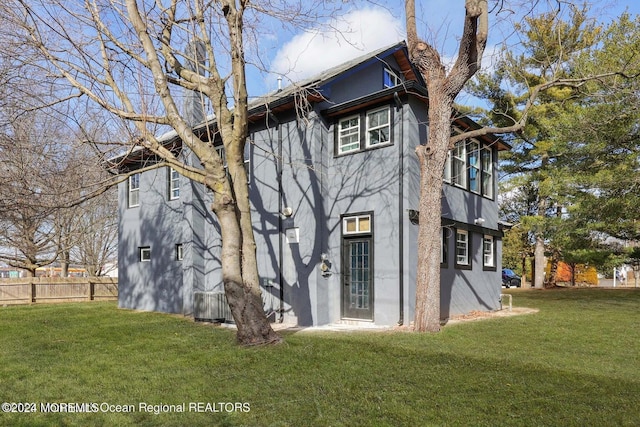 rear view of property featuring a lawn