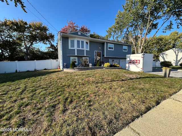 split foyer home featuring a garage and a front lawn