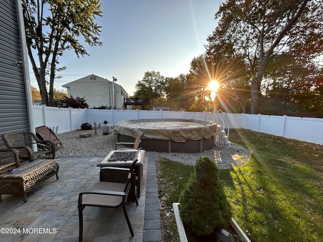 patio terrace at dusk with a fire pit and a yard