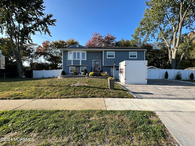 split foyer home featuring a front lawn and a garage