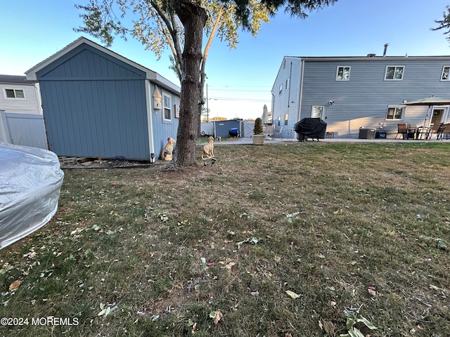 view of yard featuring a shed, a patio, and central AC unit