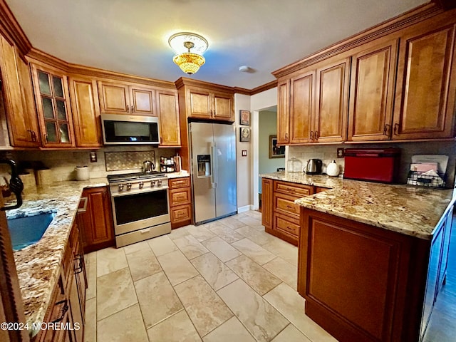 kitchen with sink, ornamental molding, stainless steel appliances, light stone counters, and decorative backsplash