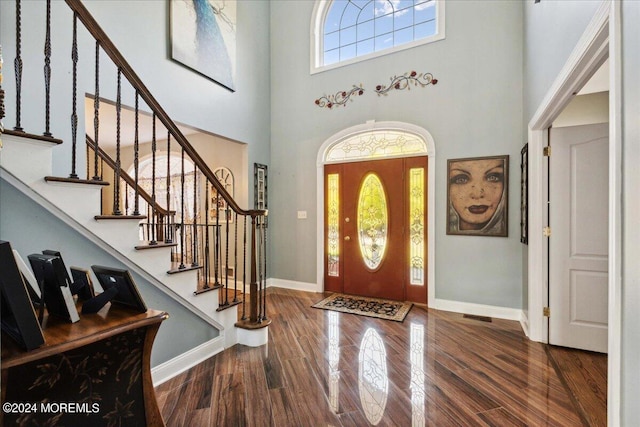 foyer entrance with wood-type flooring and a high ceiling