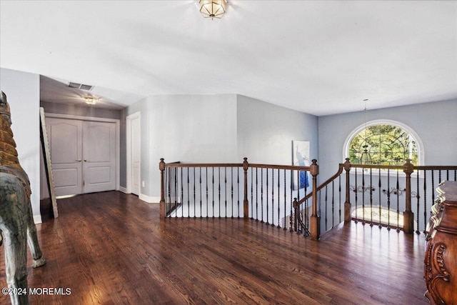 hallway with a chandelier and dark hardwood / wood-style floors