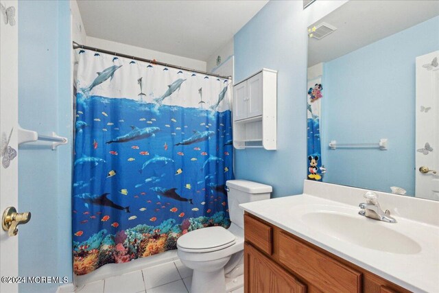 bathroom with toilet, a shower with curtain, vanity, and tile patterned flooring