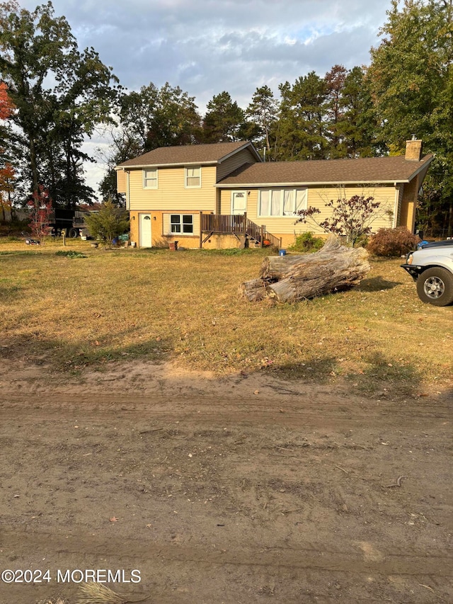 view of front of property with a front yard and a wooden deck