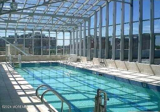 indoor community pool featuring glass enclosure