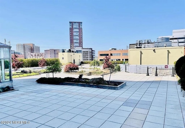 view of patio featuring a view of city and fence