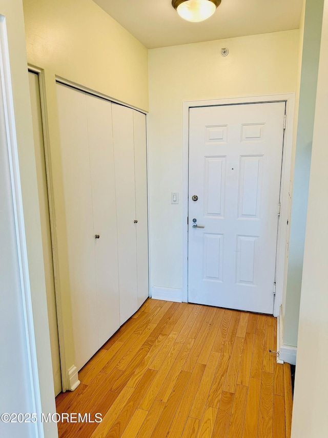 unfurnished bedroom featuring light wood-style flooring and a closet