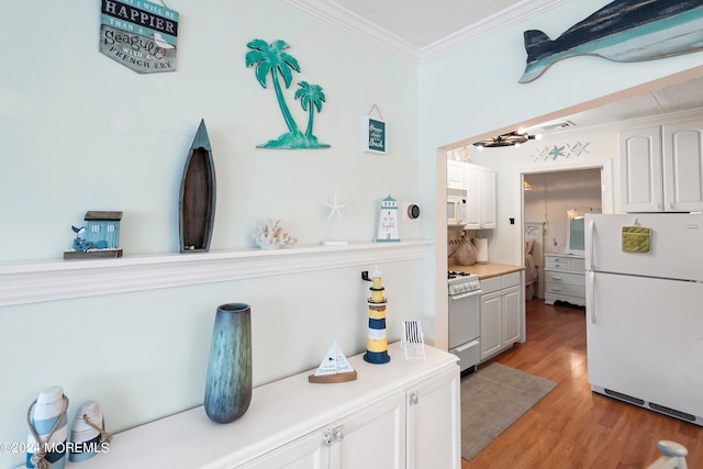 304 Bay Blvd, Seaside Heights, NJ 08751 - kitchen featuring white appliances, crown molding, light wood-style flooring, light countertops, and white cabinetry