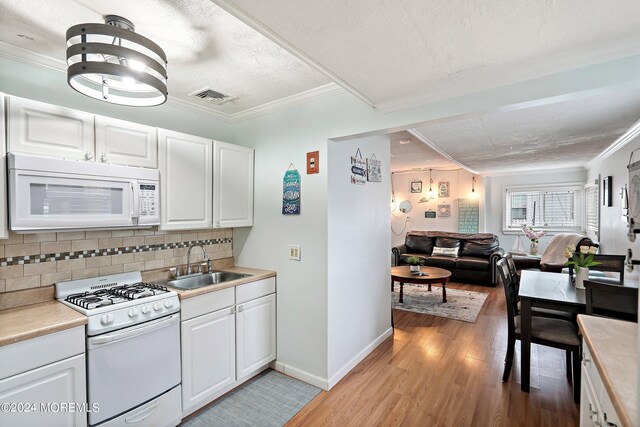 304 Bay Blvd, Seaside Heights, NJ 08751 - kitchen featuring white appliances, a sink, light wood-style floors, open floor plan, and decorative backsplash