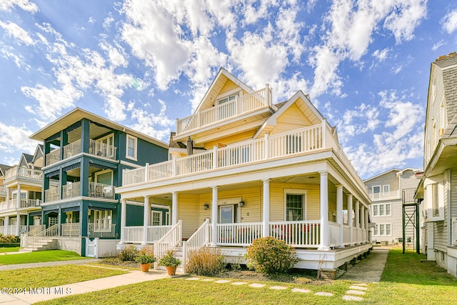 view of front of house with a balcony, a front lawn, and covered porch