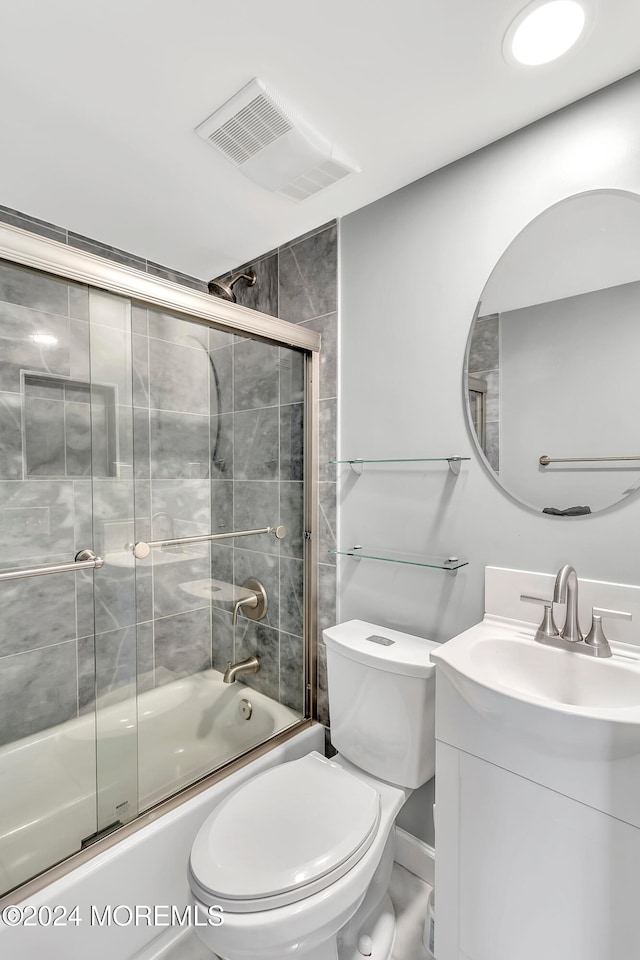 full bathroom featuring shower / bath combination with glass door, vanity, and toilet