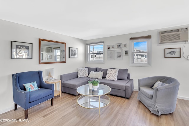 living room featuring light wood-type flooring and a wall unit AC