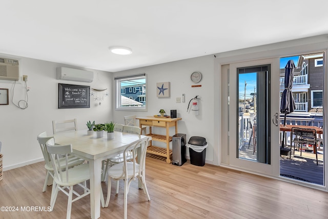 dining space featuring light wood-type flooring and a wall mounted AC