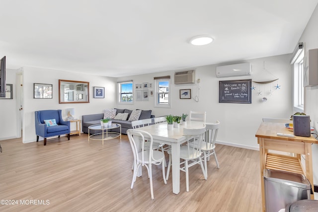 dining area featuring a wall unit AC and light hardwood / wood-style flooring