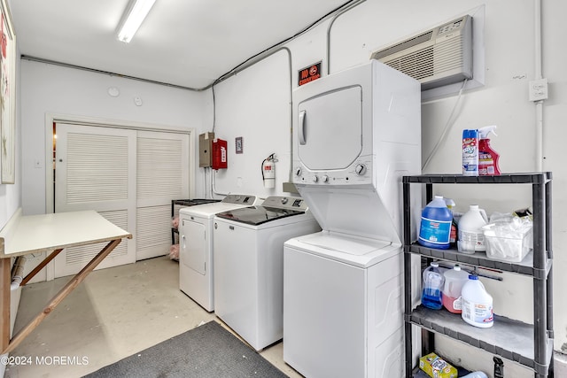 washroom with an AC wall unit and stacked washing maching and dryer