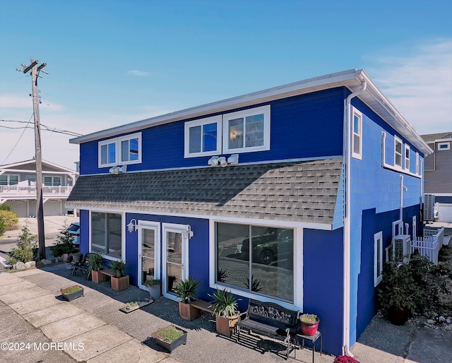 view of property featuring a garage, a patio, and central AC