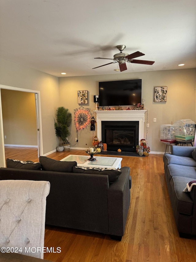 living room featuring wood-type flooring and ceiling fan