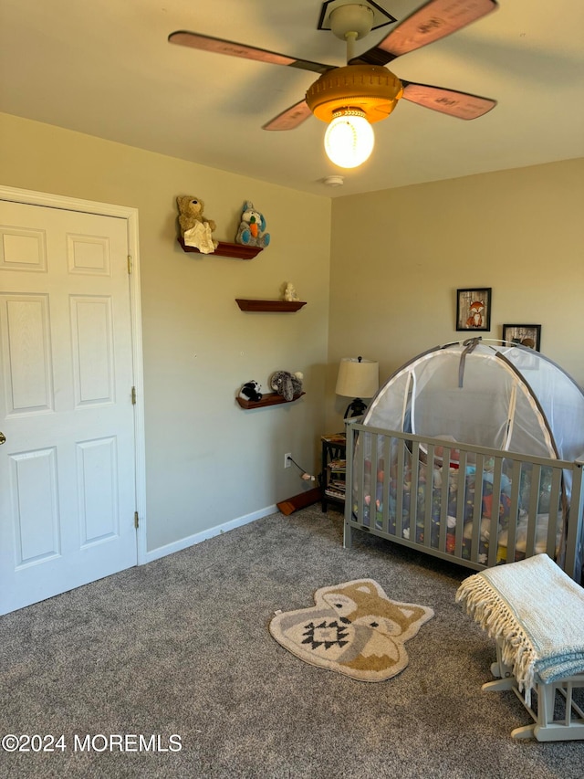 unfurnished bedroom featuring ceiling fan, carpet floors, and a nursery area