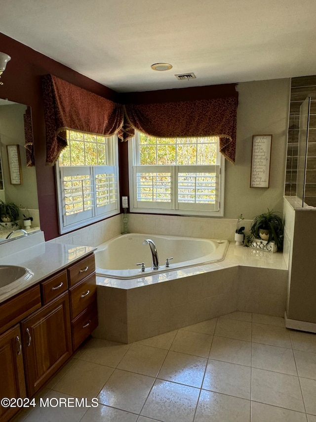 bathroom featuring vanity, tile patterned floors, and tiled tub