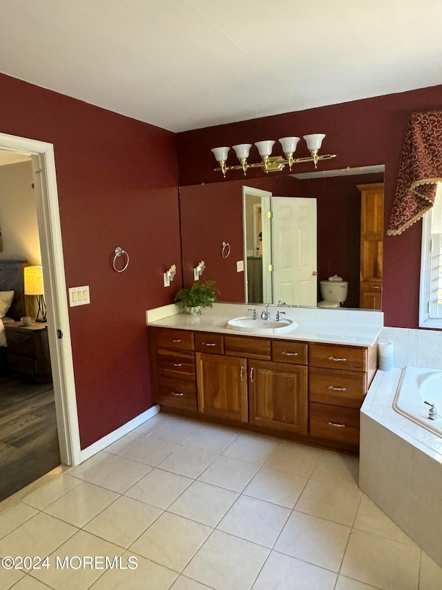 bathroom with vanity, tiled bath, and tile patterned flooring