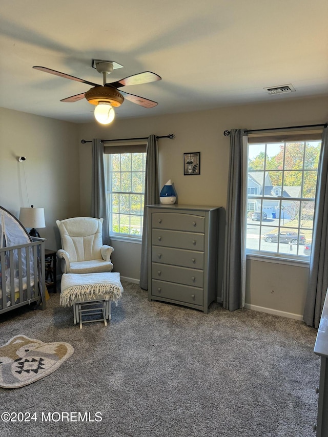 carpeted bedroom with a nursery area and ceiling fan