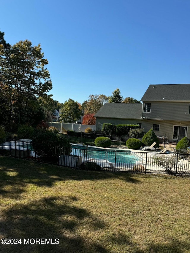 view of swimming pool with a yard