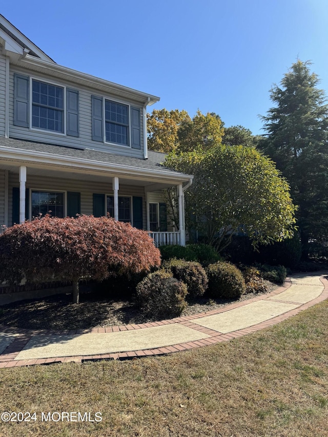 view of property exterior featuring a lawn and a porch