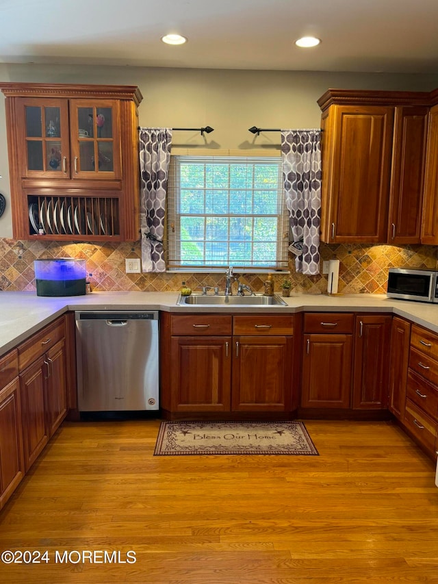 kitchen featuring light hardwood / wood-style floors, stainless steel appliances, decorative backsplash, and sink