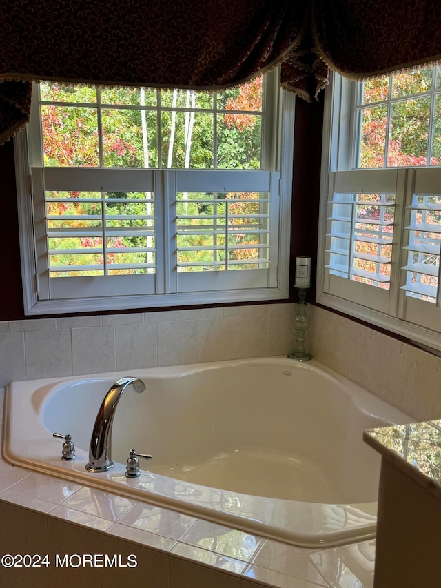 bathroom with vanity and tiled tub