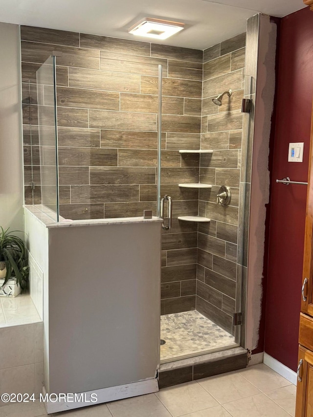 bathroom with a shower with door and tile patterned floors