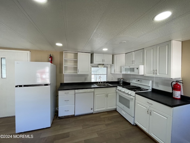 kitchen with white appliances, sink, dark hardwood / wood-style floors, and white cabinets