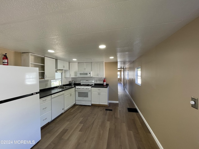 kitchen with a wealth of natural light, white cabinetry, dark hardwood / wood-style floors, and white appliances