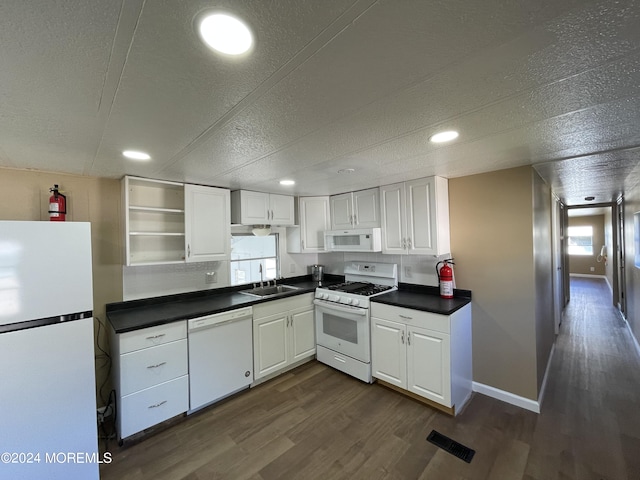 kitchen featuring dark hardwood / wood-style flooring, white cabinets, a wealth of natural light, and white appliances