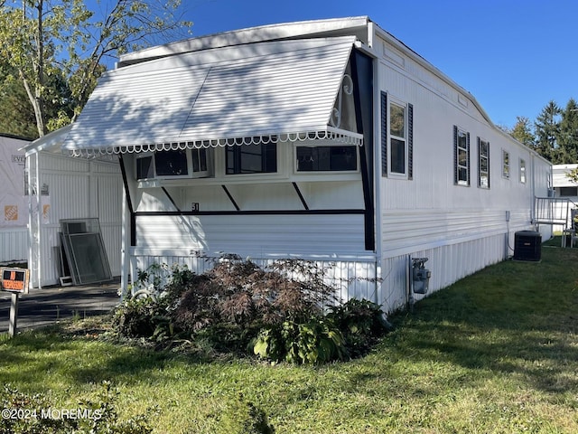 view of home's exterior with a yard and central air condition unit