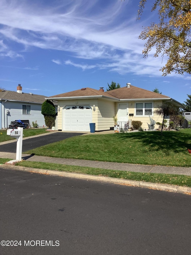 ranch-style house featuring a front lawn and a garage