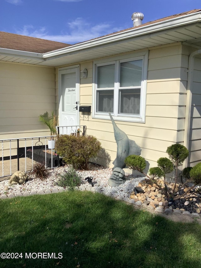 entrance to property featuring a lawn