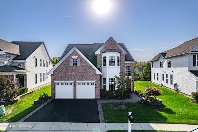 view of front of property featuring a garage and a front lawn