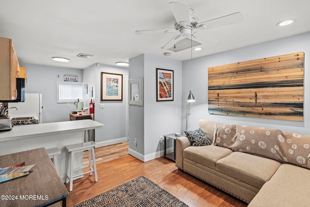 living room with light hardwood / wood-style floors and ceiling fan