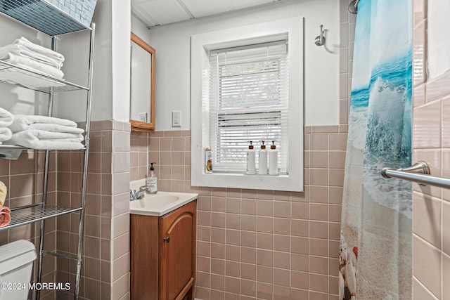 bathroom with vanity, toilet, tile walls, and a shower with shower curtain