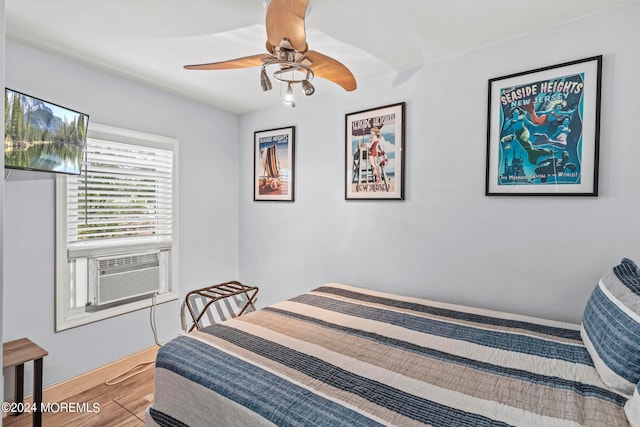 bedroom featuring hardwood / wood-style floors, cooling unit, and ceiling fan