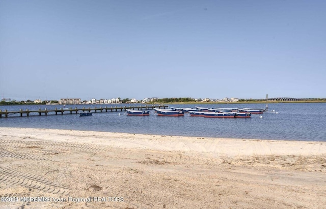 view of dock featuring a view of the beach and a water view