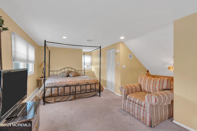 bedroom with light colored carpet and vaulted ceiling