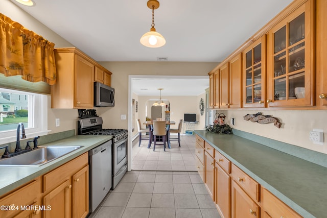 kitchen with sink, light tile patterned floors, pendant lighting, and appliances with stainless steel finishes